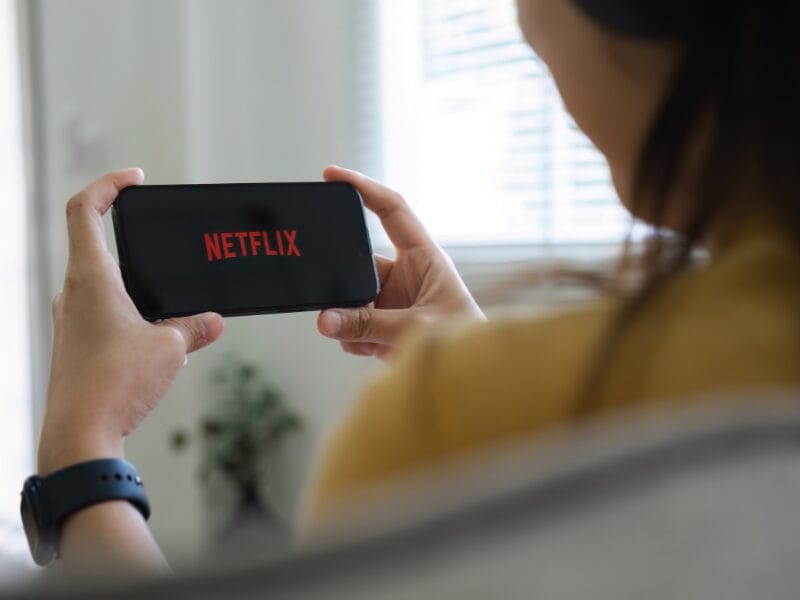 Person holding their phone watching netflix
